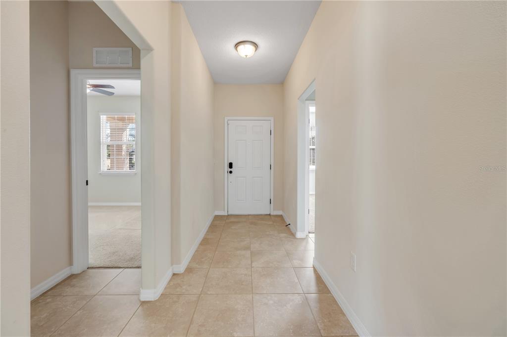 3329 Tuscano Avenue New Smyrna Beach, FL 32168 - Photo 7 of 36 a view of a hallway with wooden floor