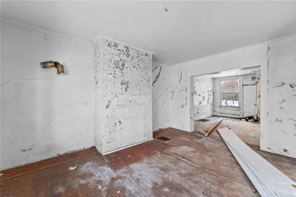 a view of a livingroom with wooden floor and a bathroom