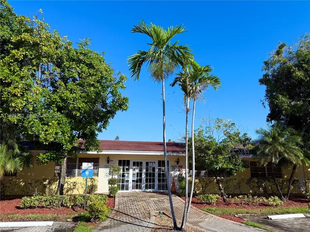 a palm tree sitting in front of a house