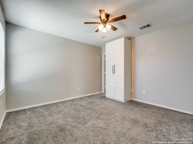 an empty room with closet and a chandelier fan