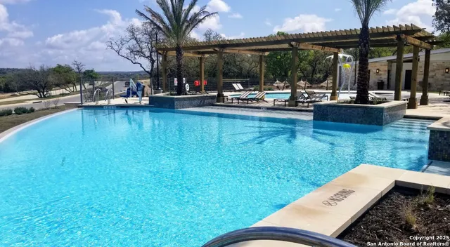 a view of swimming pool with outdoor seating and yard in the back