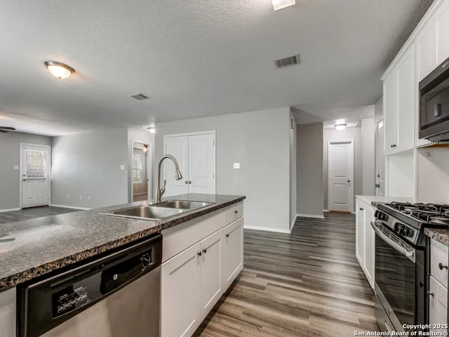 a kitchen with stainless steel appliances granite countertop a sink and a stove