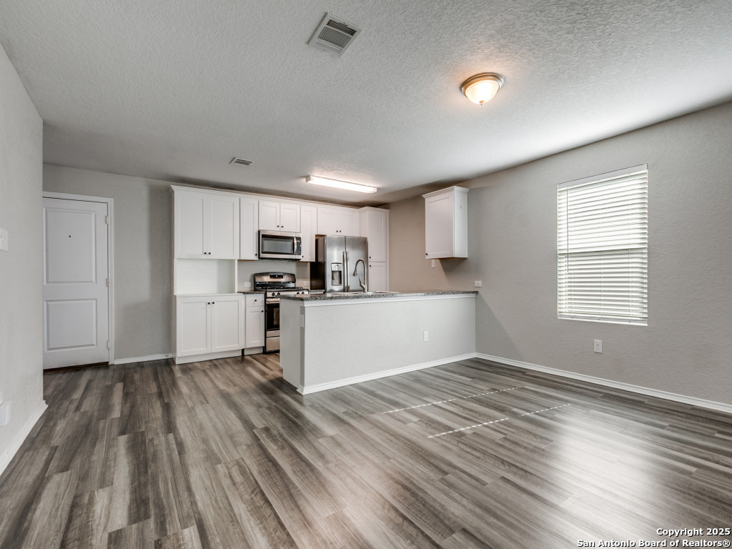 31593 Nimbus Drive Bulverde, TX 78163 - Photo 8 of 30 a view of kitchen with wooden floor electronic appliances and window