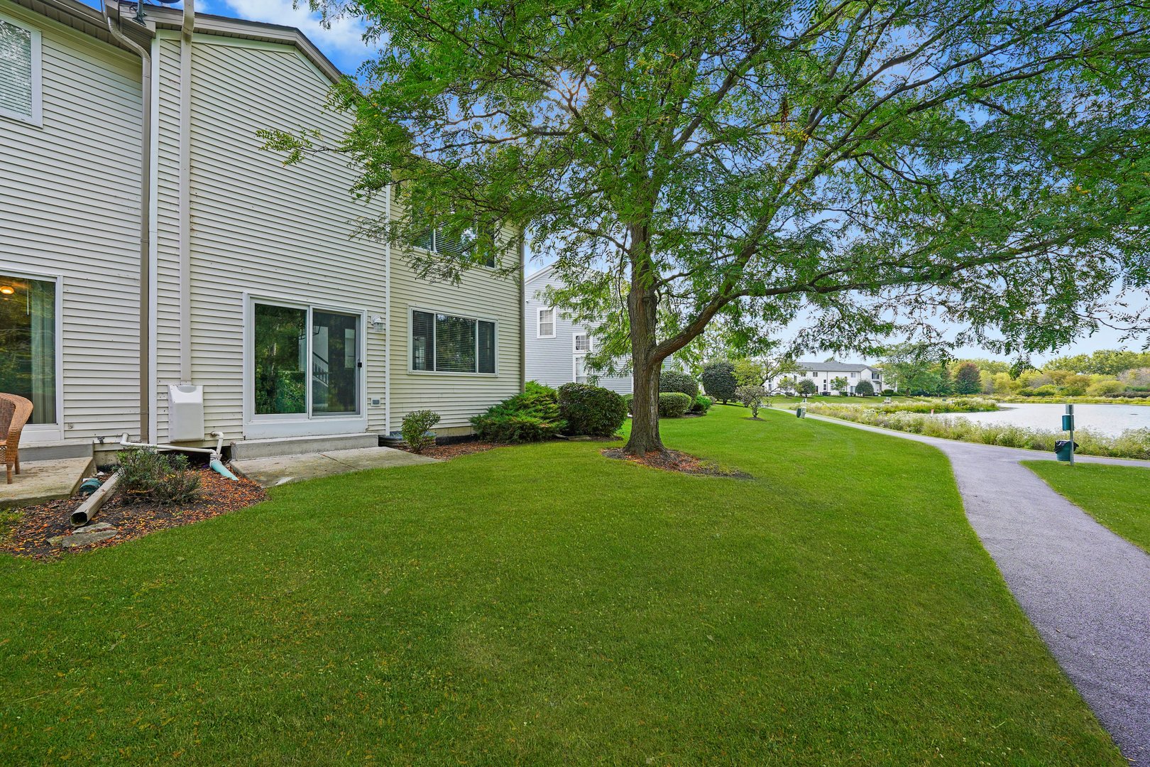 2468 Reflections Drive, Unit 2468 Aurora, IL 60502 - Photo 16 of 21 a view of a backyard with table and chairs and a large tree