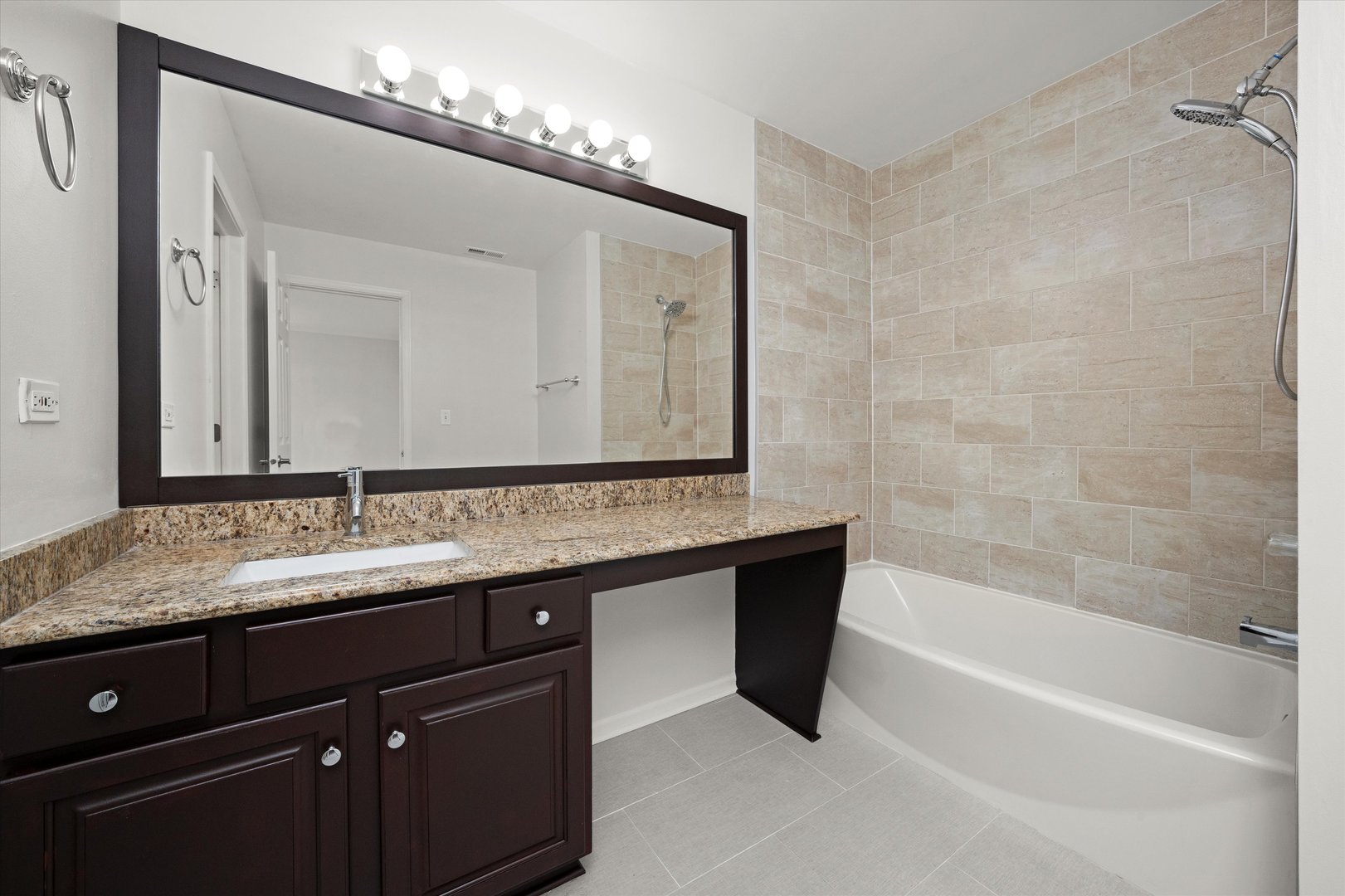 2468 Reflections Drive, Unit 2468 Aurora, IL 60502 - Photo 10 of 21 a bathroom with a granite countertop sink a large mirror and a bathtub