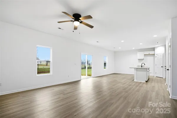 a view of empty room with wooden floor and window