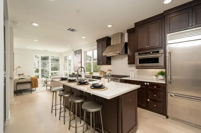 a kitchen with stainless steel appliances granite countertop a sink stove and refrigerator