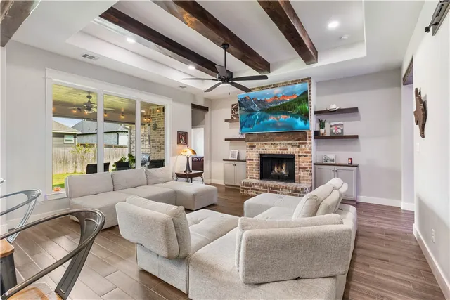 a living room with furniture a fireplace and a flat screen tv