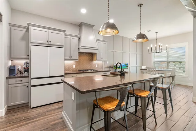 a kitchen with granite countertop a sink a center island and stainless steel appliances