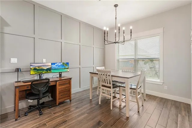 a dining room with furniture a chandelier and wooden floor