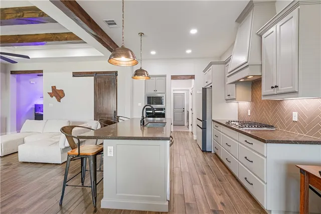 a kitchen with stainless steel appliances granite countertop a sink and cabinets