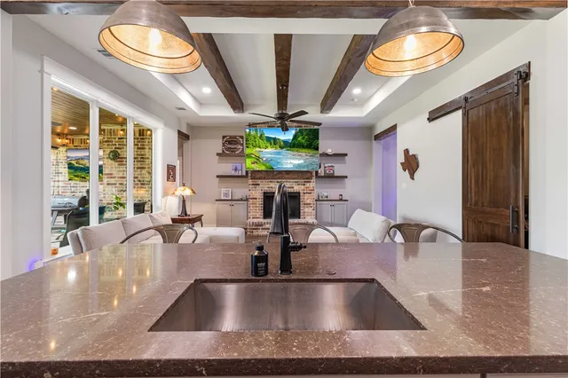 a view of kitchen with kitchen island a large window cabinets and stainless steel appliances
