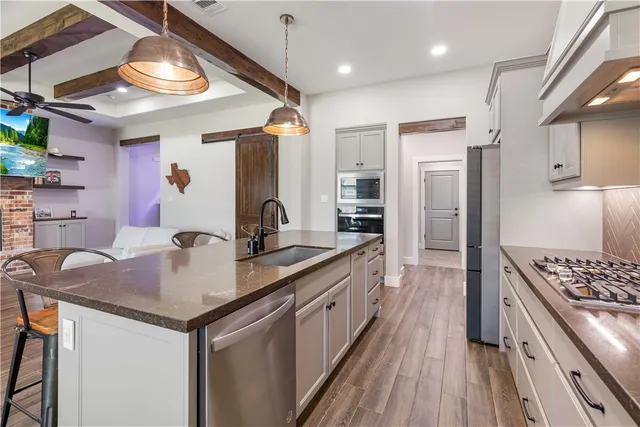 a kitchen with stainless steel appliances granite countertop a sink stove and refrigerator