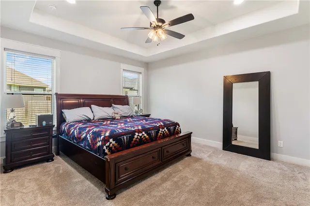 a bed sitting in a bedroom next to a window and a chandelier