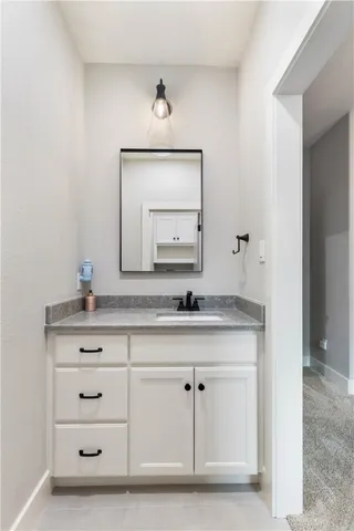a bathroom with a sink vanity and mirror