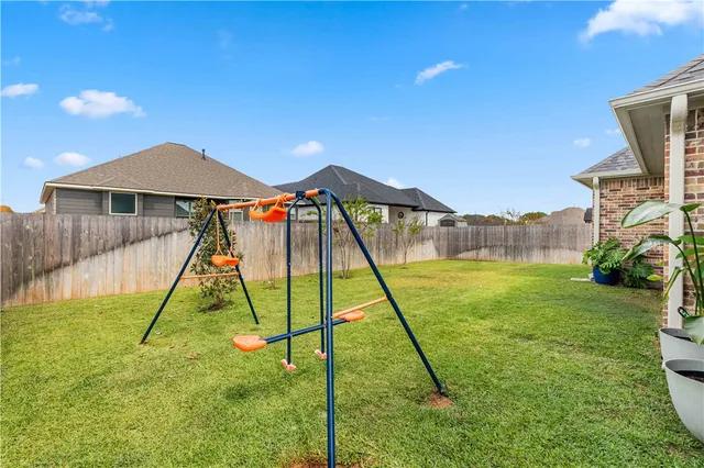 a view of a backyard with a slide and a child swing