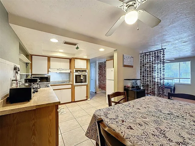 a kitchen with stainless steel appliances kitchen island granite countertop a stove refrigerator and cabinets