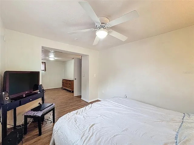 a bedroom with a bed and wooden floor