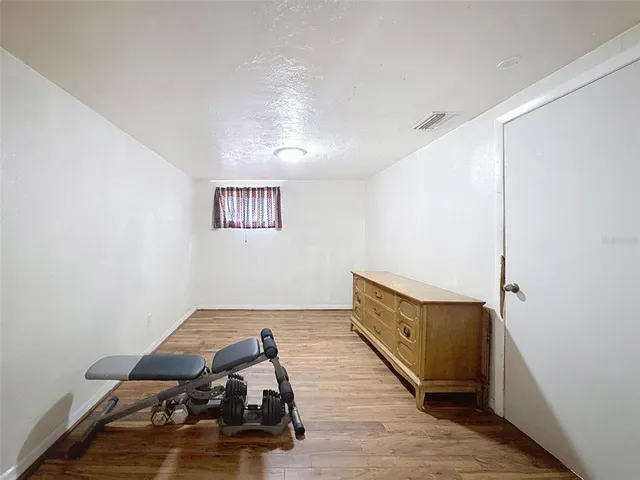 a view of a room with wooden floor and a ceiling fan