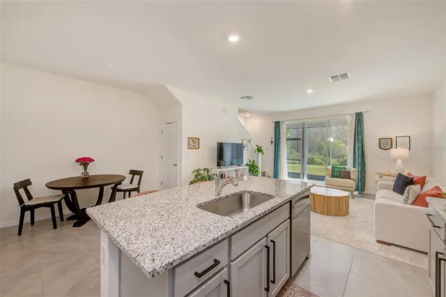 a kitchen with granite countertop white cabinets stainless steel appliances and a counter space