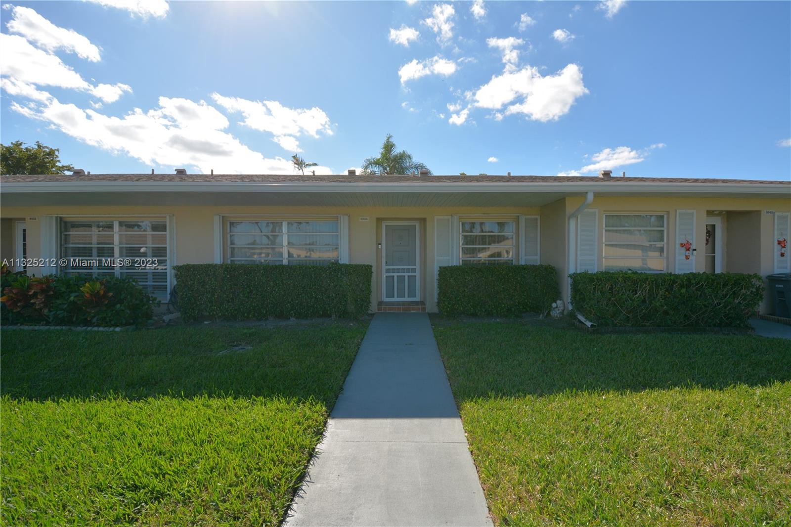 8936 Belle Aire Court, Unit 375 Boca Raton, FL 33433 - Photo 1 of 32 a front view of a house with garden