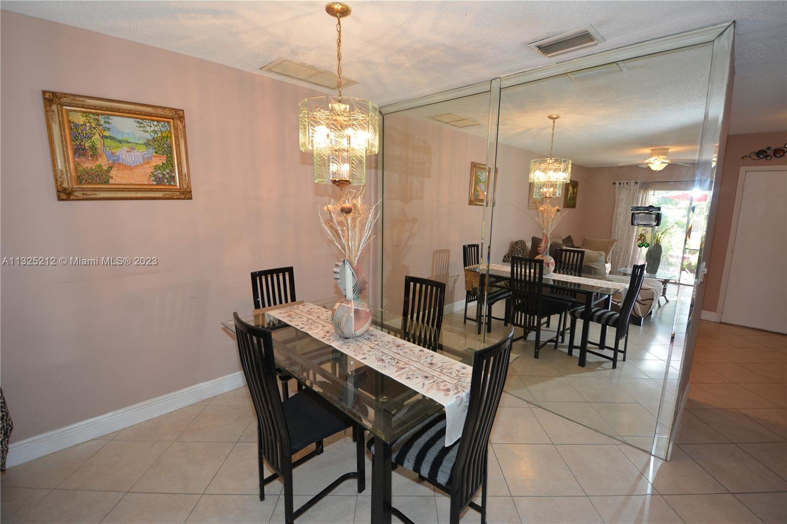 8936 Belle Aire Court, Unit 375 Boca Raton, FL 33433 - Photo 11 of 32 a view of a dining room with furniture and chandelier