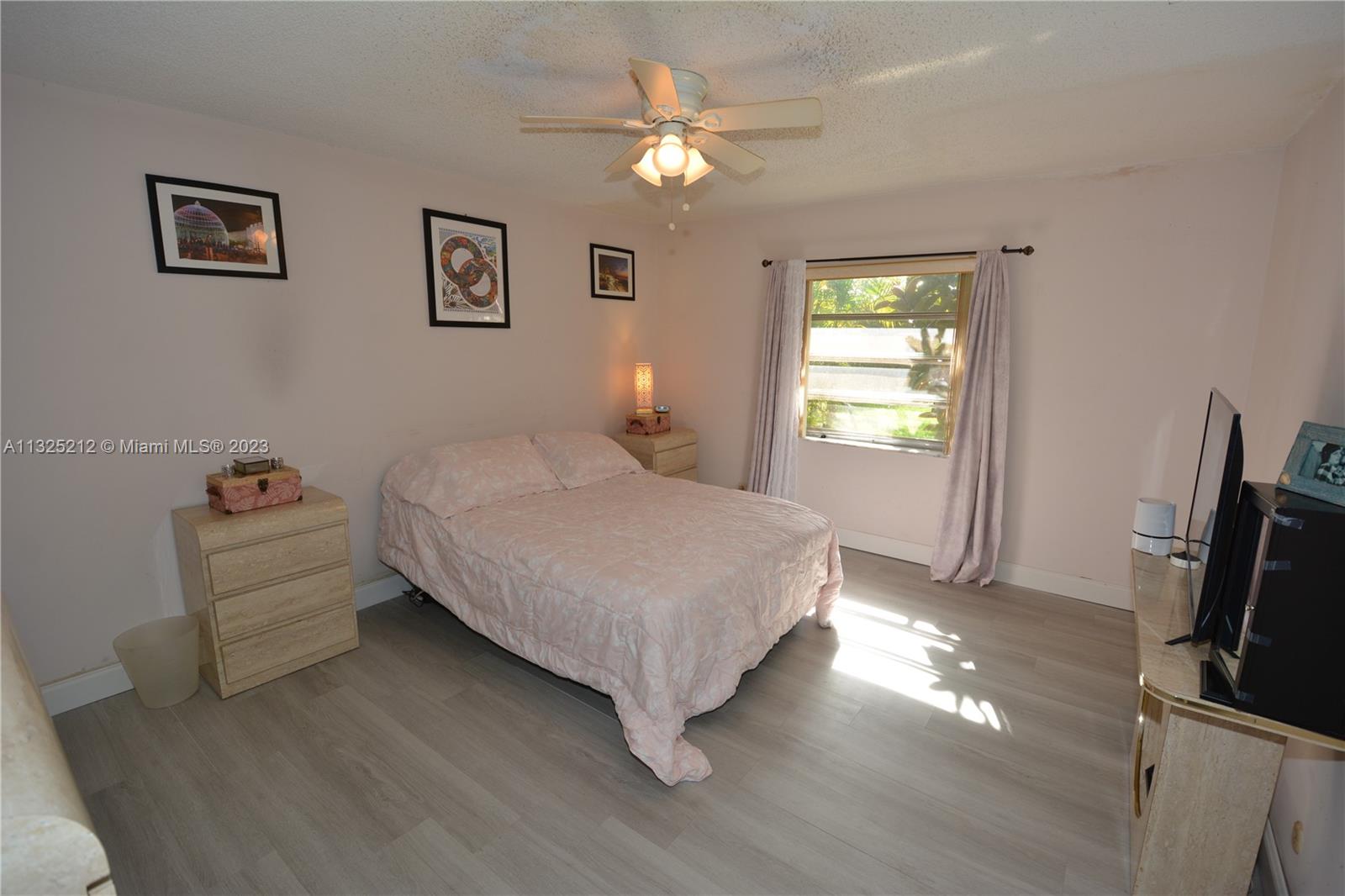 8936 Belle Aire Court, Unit 375 Boca Raton, FL 33433 - Photo 16 of 32 a bedroom with a bed and a flat screen tv
