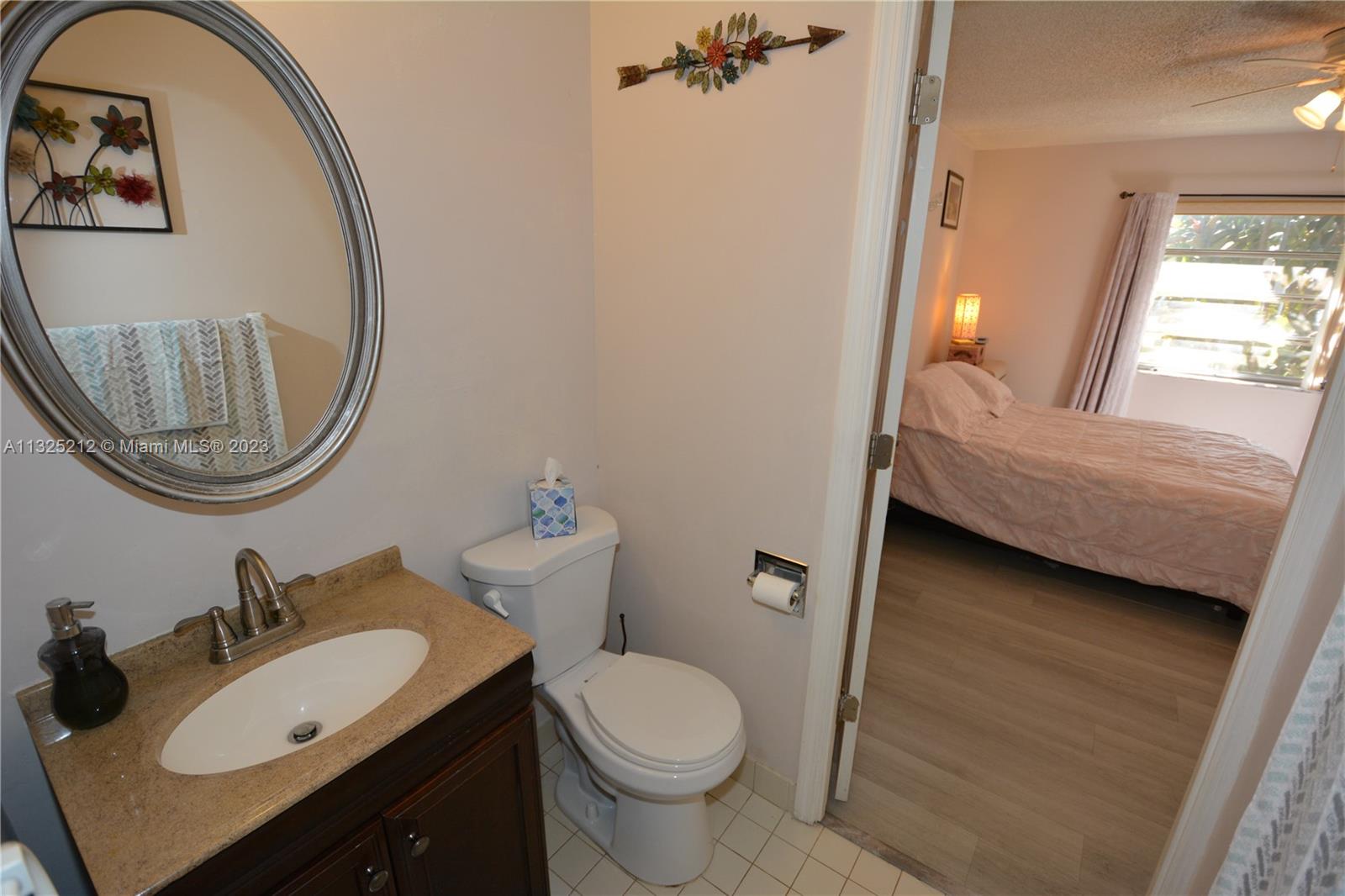 8936 Belle Aire Court, Unit 375 Boca Raton, FL 33433 - Photo 22 of 32 a bathroom with a toilet sink and mirror