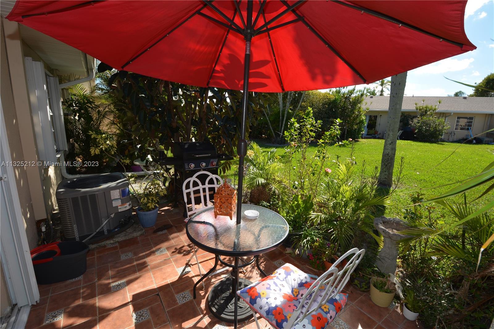 8936 Belle Aire Court, Unit 375 Boca Raton, FL 33433 - Photo 28 of 32 a view of patio with chairs and table under an umbrella