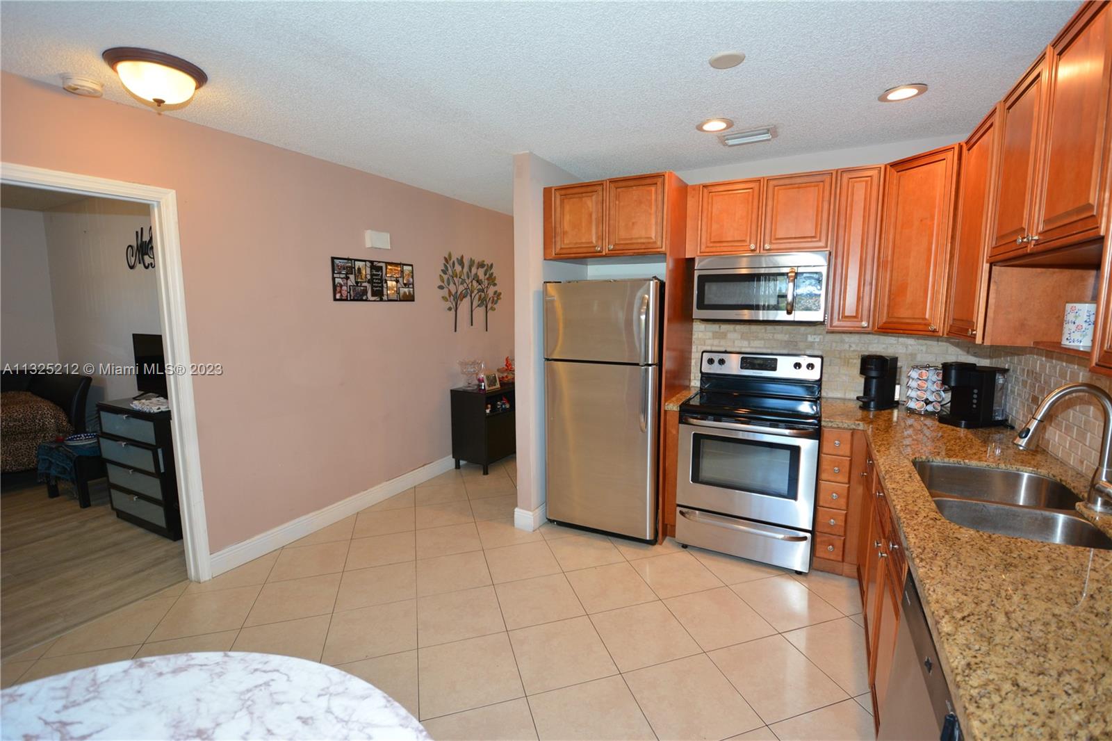 8936 Belle Aire Court, Unit 375 Boca Raton, FL 33433 - Photo 6 of 32 a kitchen with stainless steel appliances granite countertop a refrigerator and a sink