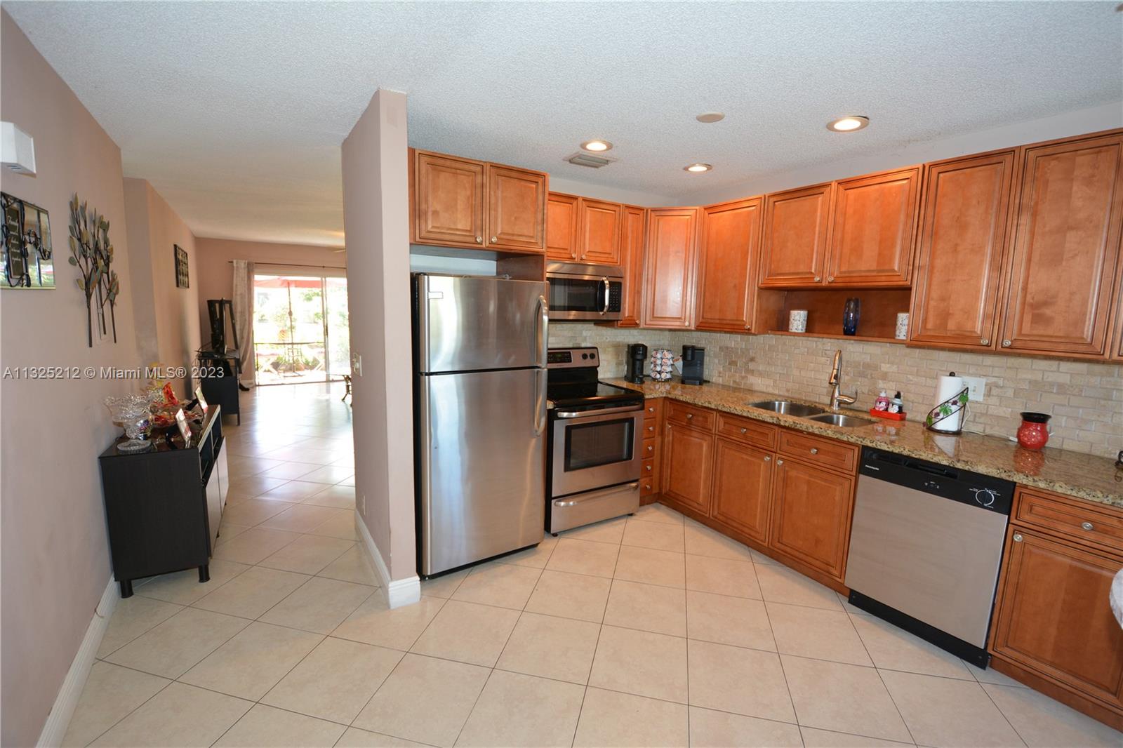 8936 Belle Aire Court, Unit 375 Boca Raton, FL 33433 - Photo 8 of 32 a kitchen with stainless steel appliances granite countertop a refrigerator and a stove top oven
