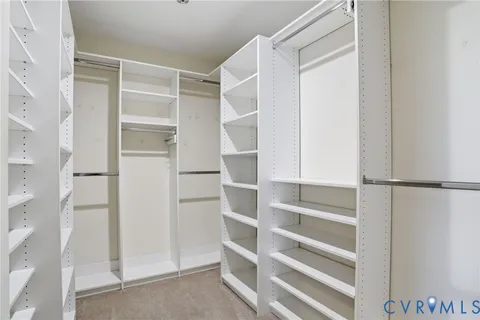 a view of walk in closet with empty racks