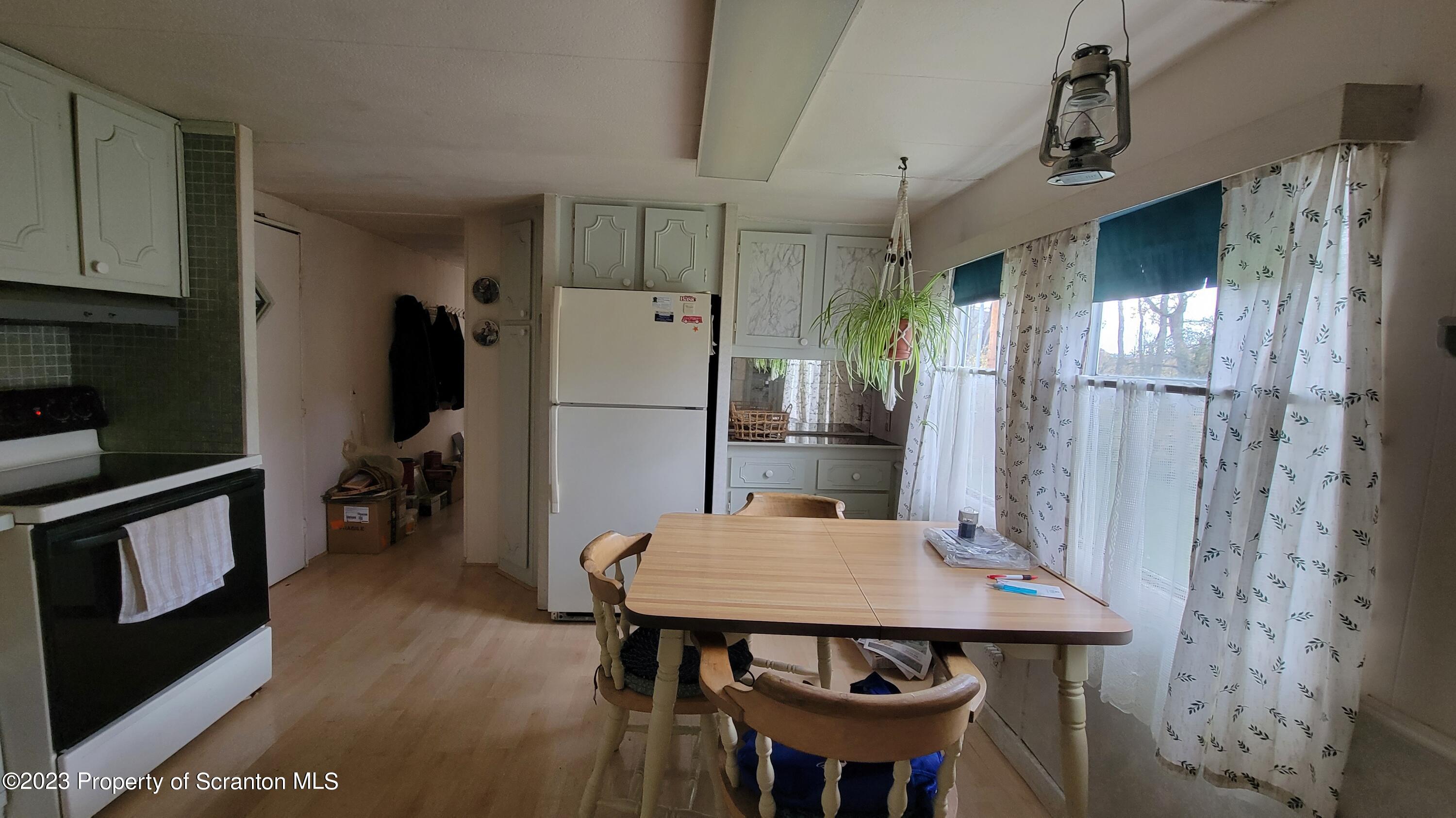 64 Franklin Street Great Bend, PA 18821 - Photo 10 of 17 a kitchen with stainless steel appliances a dining table chairs and refrigerator
