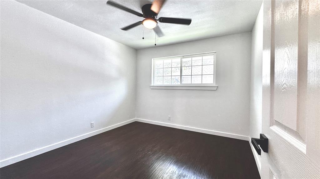 3315 Cedarcroft Lane Dallas, TX 75233 - Photo 11 of 19 an empty room with wooden floor fan and windows