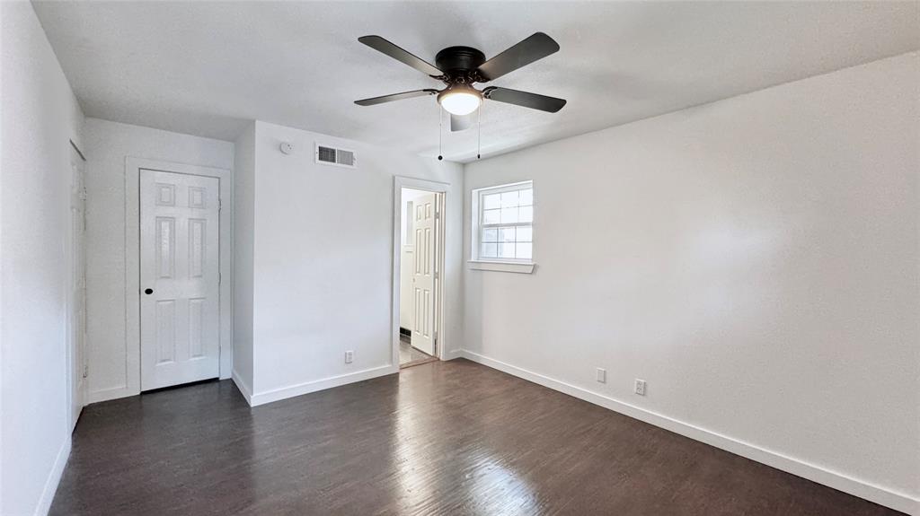 3315 Cedarcroft Lane Dallas, TX 75233 - Photo 16 of 19 an empty room with wooden floor chandelier fan and windows