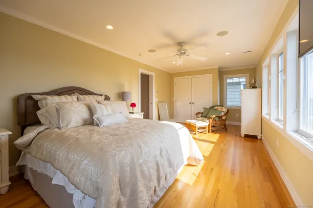 a spacious bedroom with a bed and wooden floor