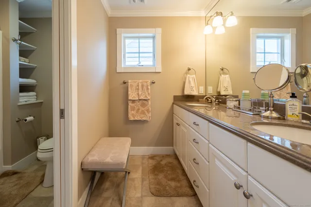a spacious bathroom with a granite countertop sink a toilet and a mirror