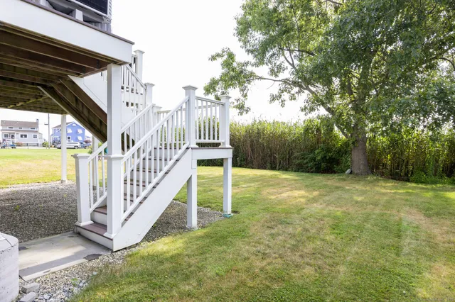 a view of a yard with porch and wooden fence
