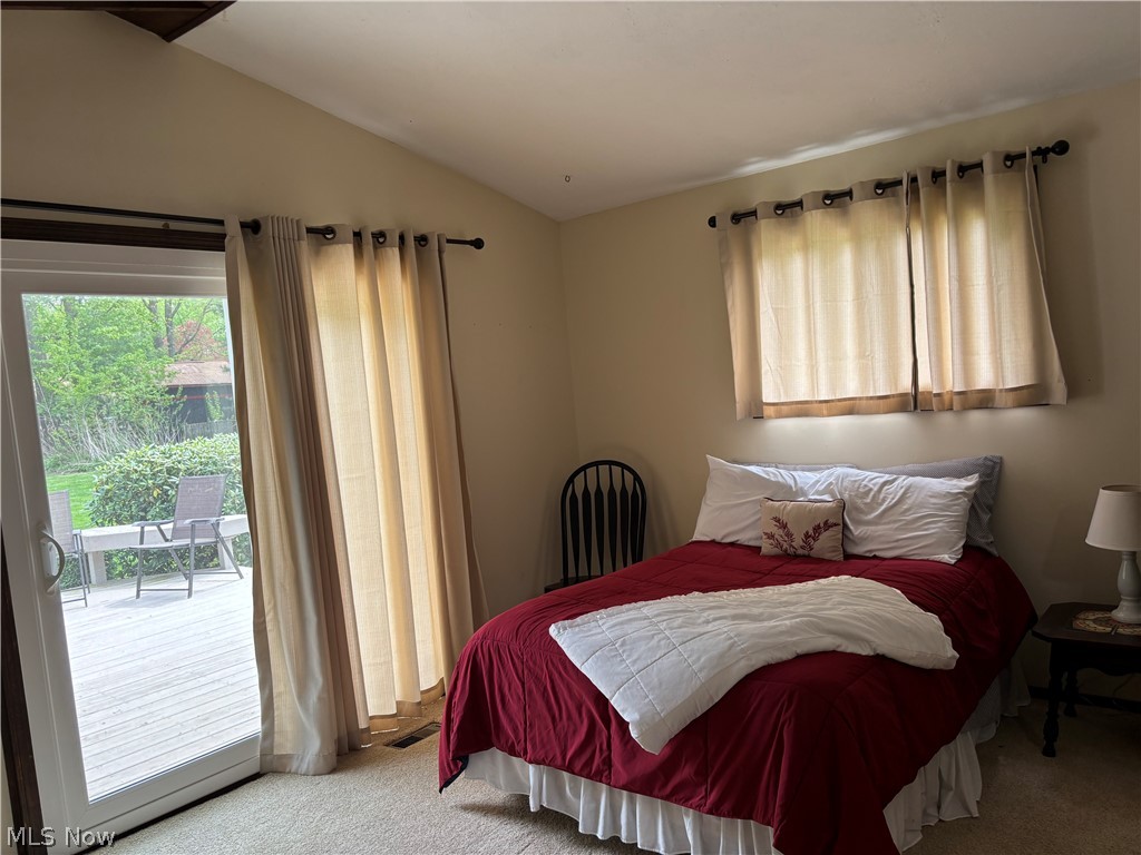 5595 Meister Road Mentor, OH 44060 - Photo 12 of 26 Bedroom featuring carpet floors, access to exterior, vaulted ceiling, and multiple windows
