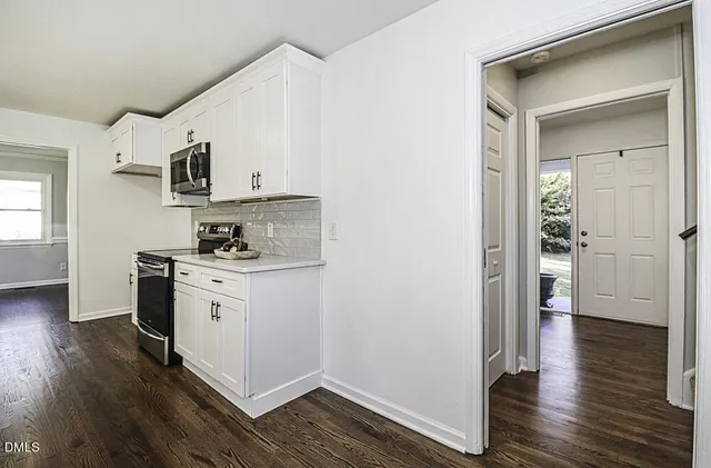 a kitchen with granite countertop a refrigerator and a stove top oven