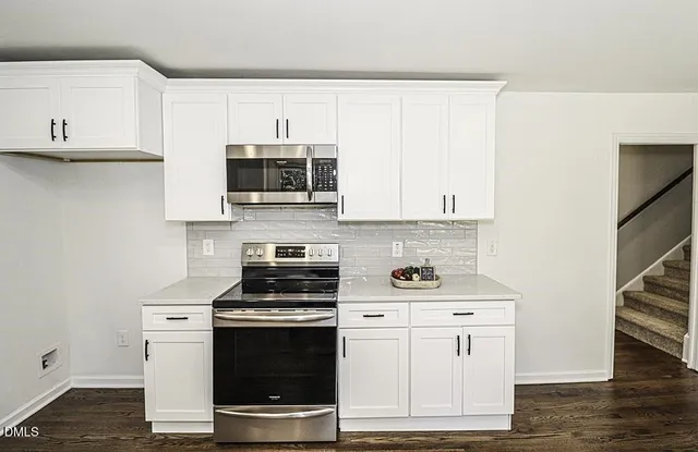 a kitchen with stainless steel appliances a stove a microwave and cabinets