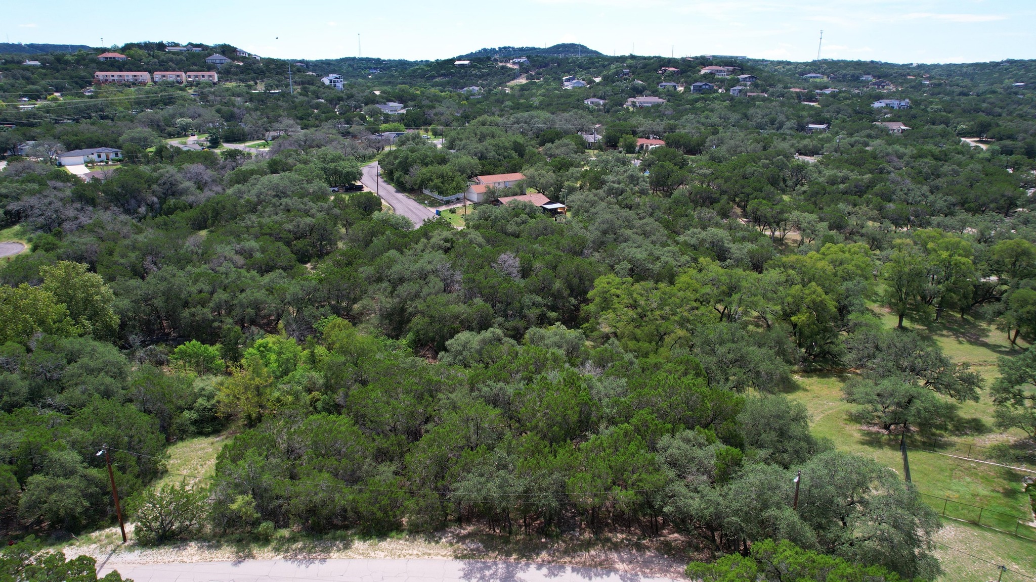 6719 Bar K Ranch Road Lago Vista, TX 78645 - Photo 6 of 36 an aerial view of a houses with a lush green hillside