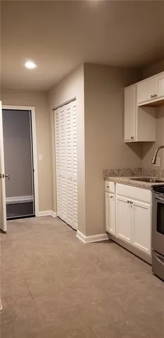 a view of a kitchen with white cabinets and white appliances
