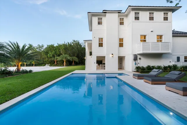 a kitchen with stainless steel appliances kitchen island granite countertop a table and chairs in it