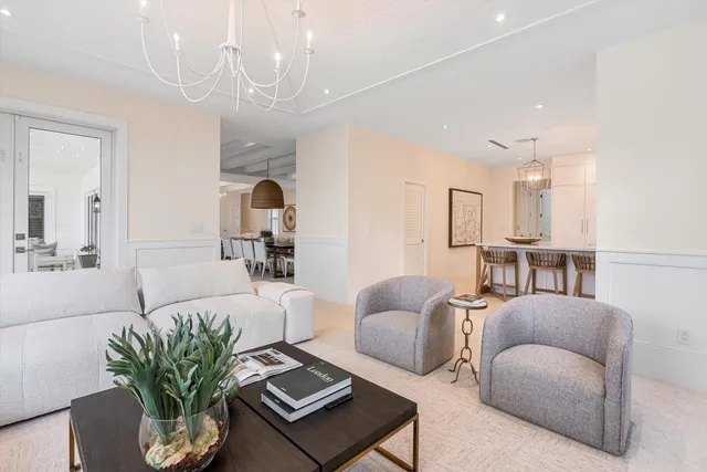 a bedroom with a large bed a chandelier and dresser