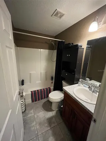 a bathroom with a sink a toilet a mirror and shower