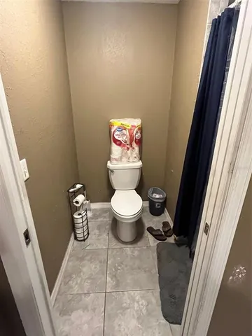 a bathroom with a toilet and a shower curtain