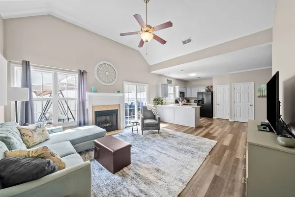a living room with furniture a fireplace and a flat screen tv