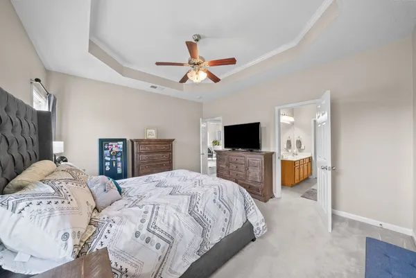 a spacious bedroom with a bed and a flat screen tv