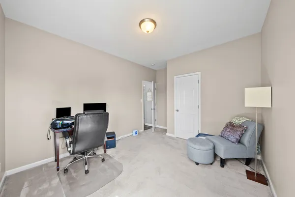a view of a workspace with furniture and a window